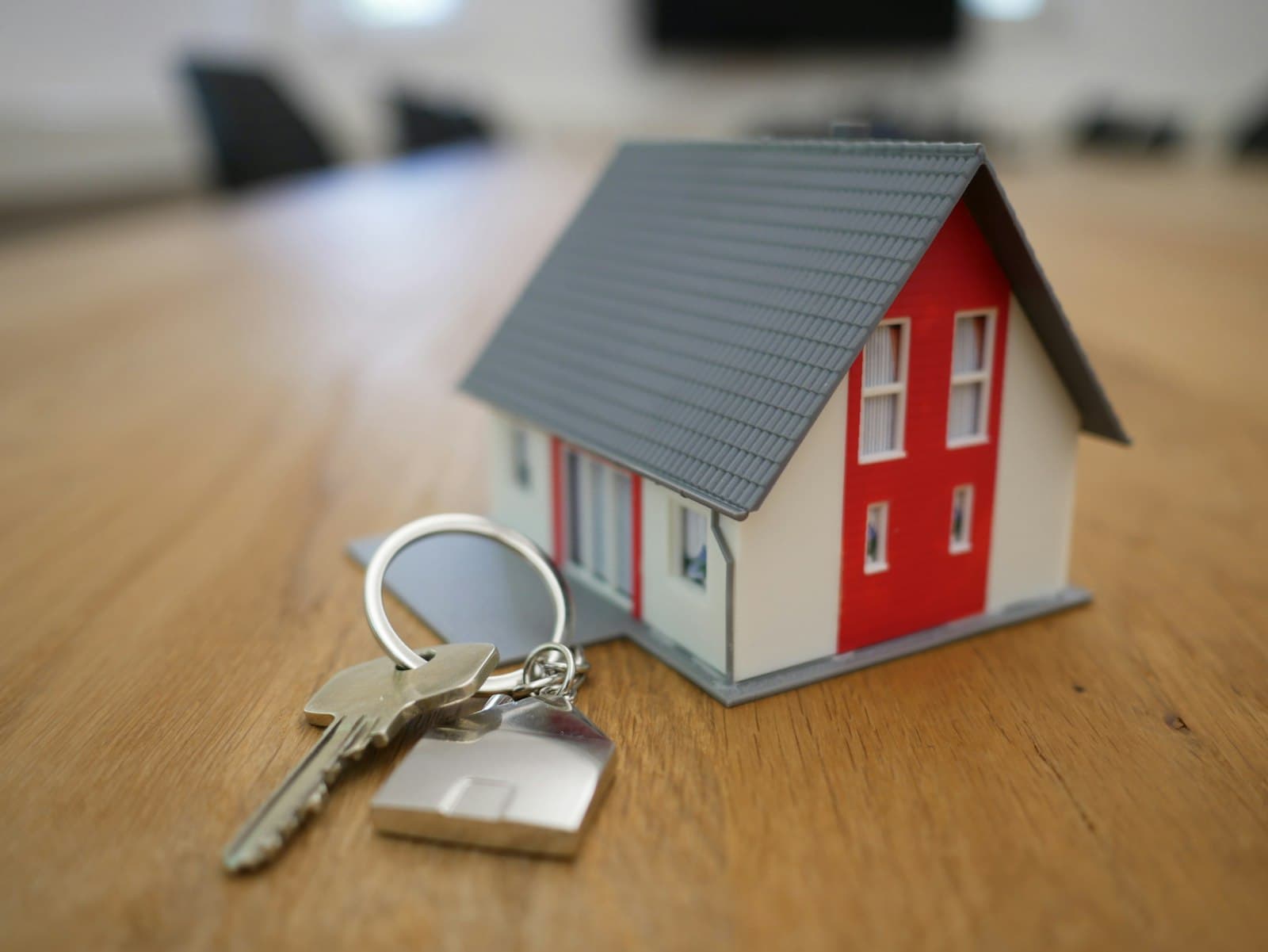 Hausmodell mit Schlüssel als Symbol für den Immobilienkauf